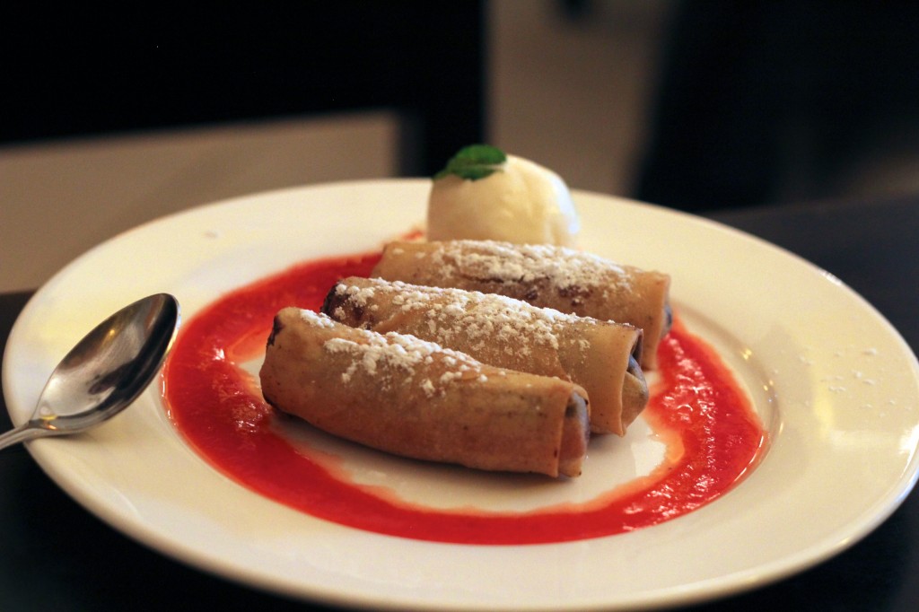 Nems fourrés à la banane et au chocolat sur leur lit de fruits rouges et accompagnés de sa boule de glace à la vanille