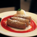 Nems fourrés à la banane et au chocolat sur leur lit de fruit rouge et accompagnés de sa boule de glace à la vanille