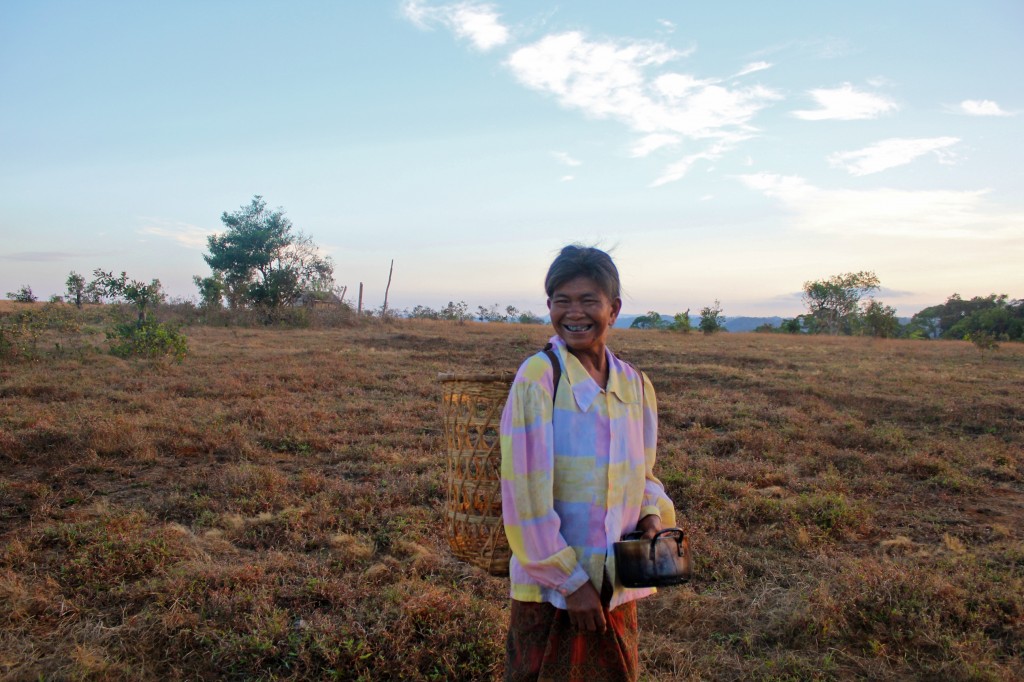 Femme phnong allant chercher de l'eau à la rivière avec son panier typique sur le dos