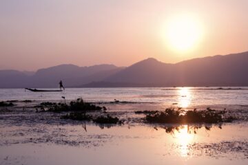 Pêcheur intha sur fond de couché de soleil sur le lac Inlé