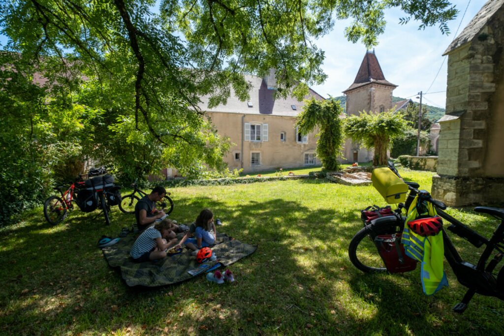 Pause à l'ombre dans le jardin de l'église d'Aiglepierre en voyage à vélo dans le Jura